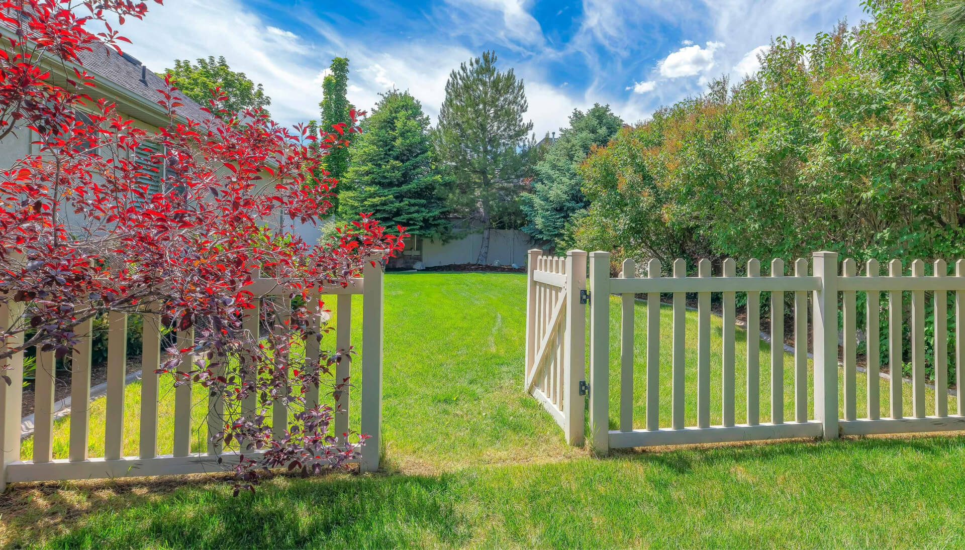 A functional fence gate providing access to a well-maintained backyard, surrounded by a wooden fence in Dallas